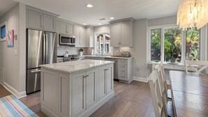 A modern kitchen with grey cabinets, stainless steel appliances, and a large island. - Fairway Oaks Villa! Lagoon views! Short 5-7 minute stroll to the beach! (Kiawah Island)
