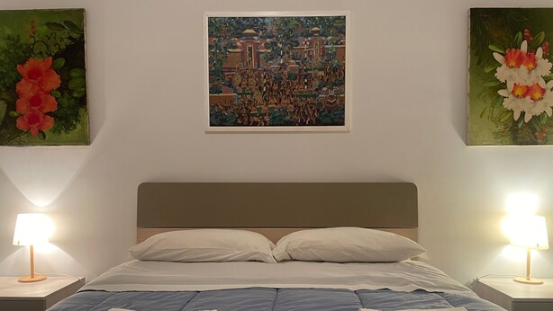 Een hotelkamer met een bed, twee nachtkastjes en twee wandlampen.