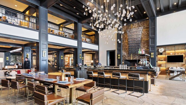 A spacious, modern hotel lobby with a high ceiling, a central bar area, and multiple seating options. - Hyatt Residence 2052 - 2 Bedroom Residence (Beaver Creek)