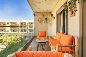 Relax on the balcony with a sofa set and enjoy the serene view of the well-maintained garden.