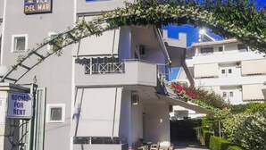 A modern building with a sign indicating rooms for rent.