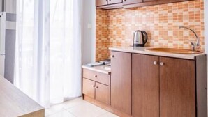 A modern kitchen with wooden cabinets, a tiled backsplash, and a stainless steel sink.