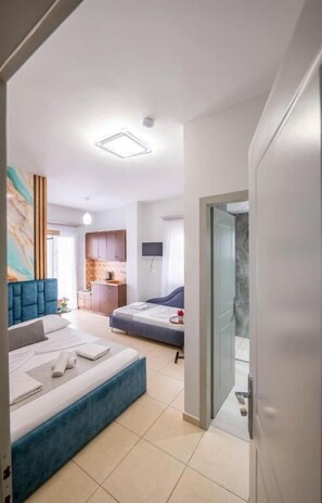 Una habitación de hotel moderna con cama, escritorio y kitchenette.