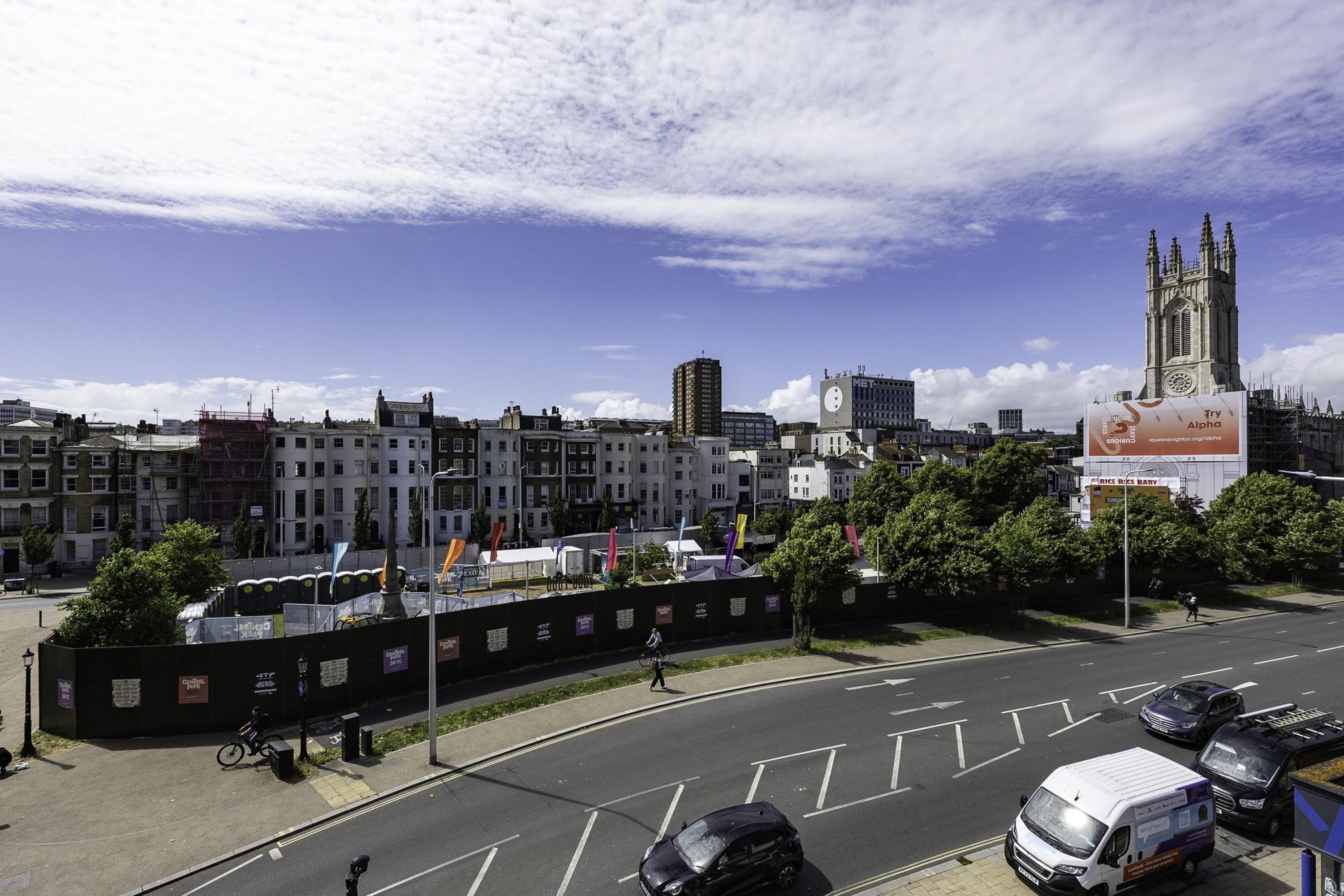 Une rue de la ville avec des immeubles, une tour de l’horloge et un chantier de construction.