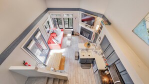 Un ampio soggiorno a pianta aperta con cucina, zona pranzo e una scala che conduce a un piano superiore.
