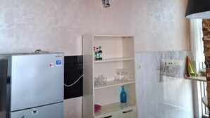 A kitchen with a built-in refrigerator, a wooden cabinet with shelves, and a marble countertop. - 3-bedroom apartment in Batumi (Batumi)