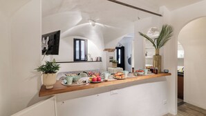 A kitchen with a wooden countertop, various food items, and a potted plant.