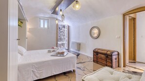 A bedroom with a bed, a chest of drawers, a mirror, and a window. - Boutique Apartment Casa Del Nobile (Ventimiglia)
