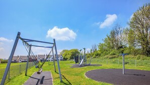 A playground with swings, slides, and climbing structures. - Castle Park is a fantastic gem of a property located in Paignton. (Paignton)