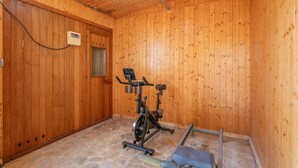 A wooden room with an exercise bike and a bench. - Holiday Home 'Beniarbeig' with Mountain View, Wi-Fi and Air Conditioning (El Campello)