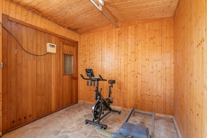 A wooden room with an exercise bike and a bench. - Holiday Home 'Beniarbeig' with Mountain View, Wi-Fi and Air Conditioning (El Campello)