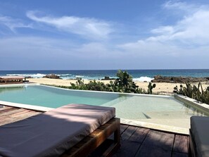 A poolside area with a view of the beach and ocean.
