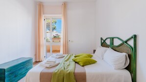 Un dormitorio con una cama, un banco y vistas al exterior.