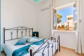 Una camera da letto con un letto, una finestra e un condizionatore d'aria.