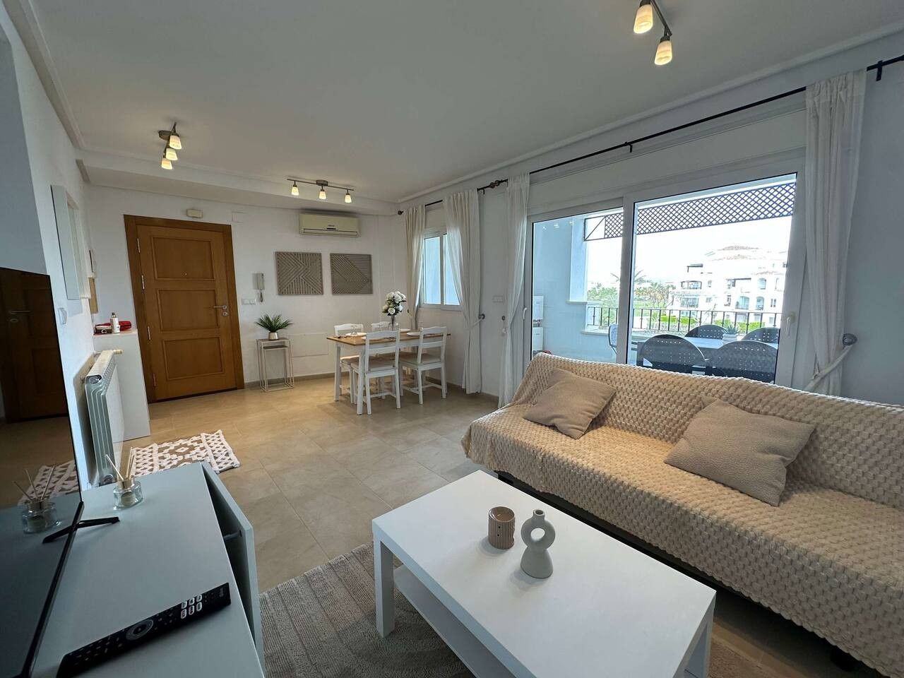 Un salon moderne comprenant un canapé, une table basse et un coin repas avec une table et des chaises.