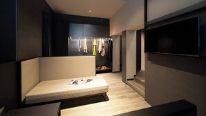 A modern hotel room with a bed, a seating area, a wardrobe, and a TV. - 7BA Hotel Milano (Milan)