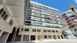 A multi-story residential building with balconies, large windows, and a flat roof. - 4BNB - Porta Portese Cozy Apartment (Rome)