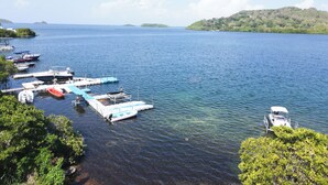 A marina with boats docked, surrounded by lush greenery and hills in the background. - Villa Pantone - Three Bedroom Villa, Sleeps 6 (Le Robert)