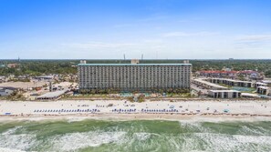 Un grand hôtel à plusieurs étages, situé en bord de mer et doté d’une piscine.