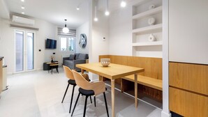 Una cocina moderna con una mesa y sillas de madera, un banco empotrado y una estantería de pared.