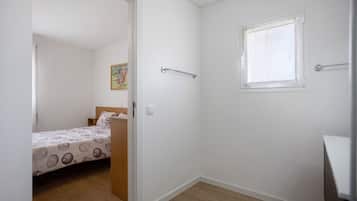 Une chambre à coucher avec un lit, une fenêtre et une porte donnant sur une autre pièce.