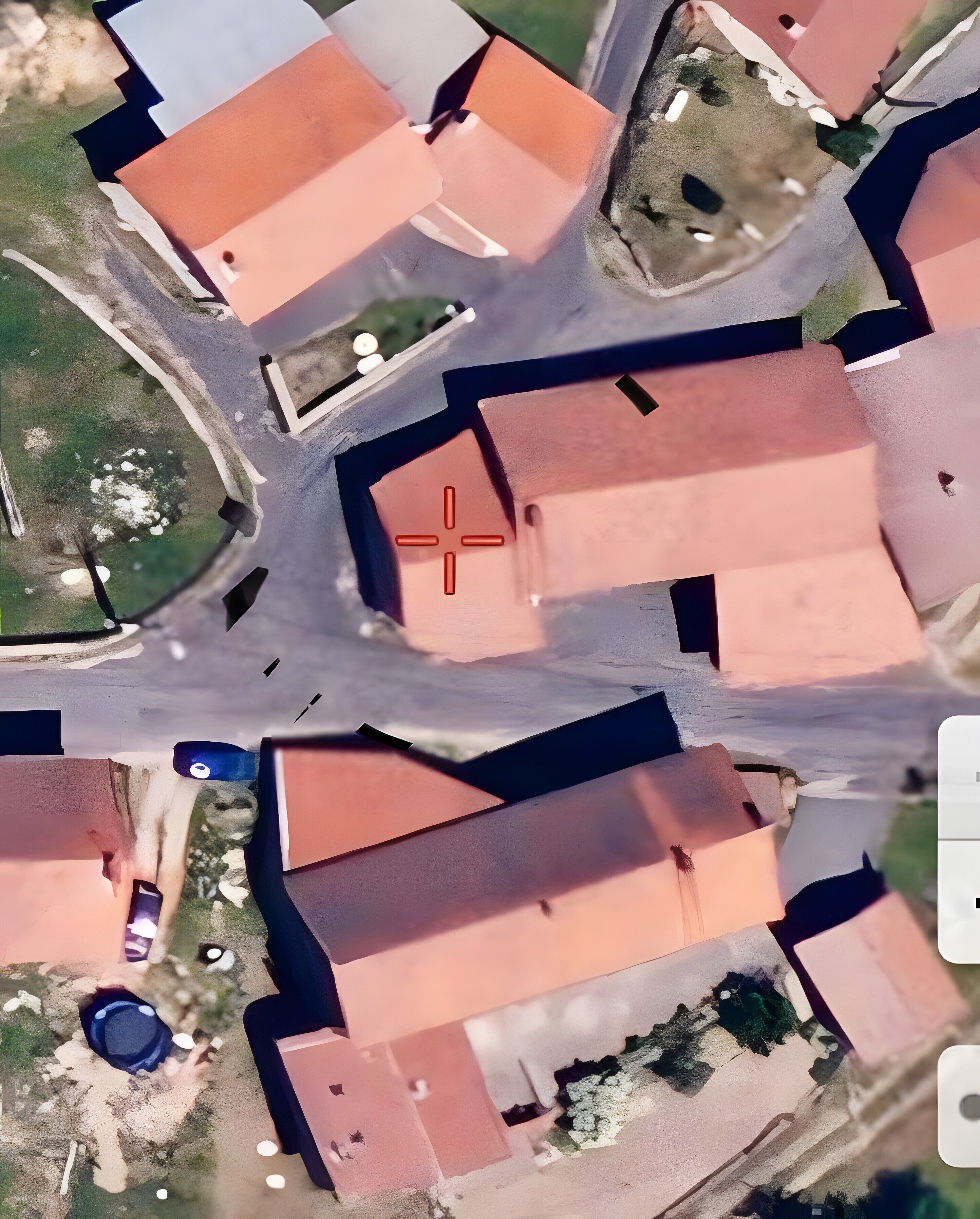 Vue aérienne d’un quartier résidentiel avec de nombreuses maisons, un carrefour central et un petit plan d’eau.