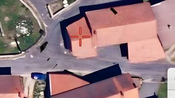Vue aérienne d’un quartier résidentiel avec de nombreuses maisons, un carrefour central et un petit plan d’eau.