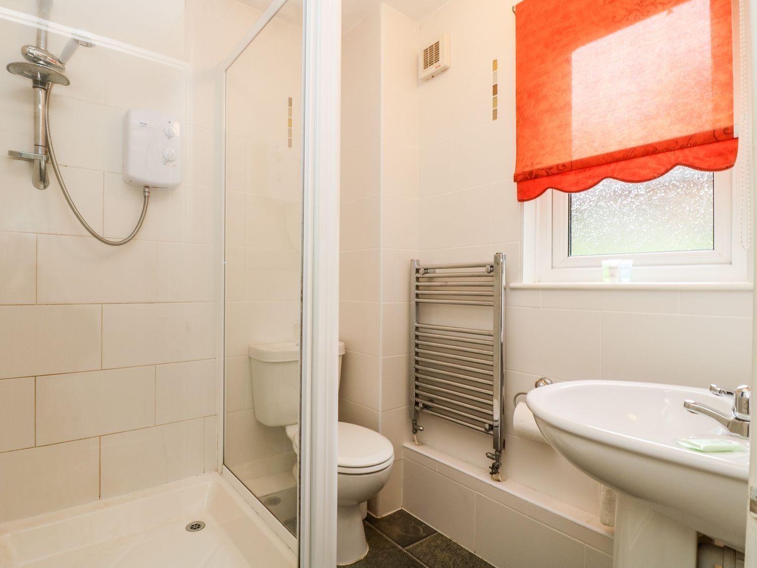 A bathroom with a glass-enclosed shower, a toilet, a bathtub, and a sink.