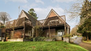 A modern two-story house with a wooden facade, a balcony, and a garage. - Valley Lodge 31 (Gunnislake)