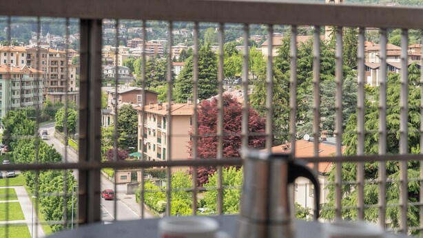 A balcony with a view of mountains and a cityscape.
