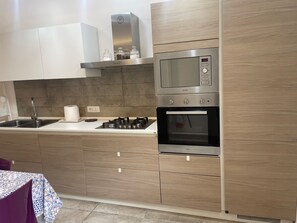 Une cuisine moderne équipée d’une cuisinière, d’un four et d’un four à micro-ondes en acier inoxydable.