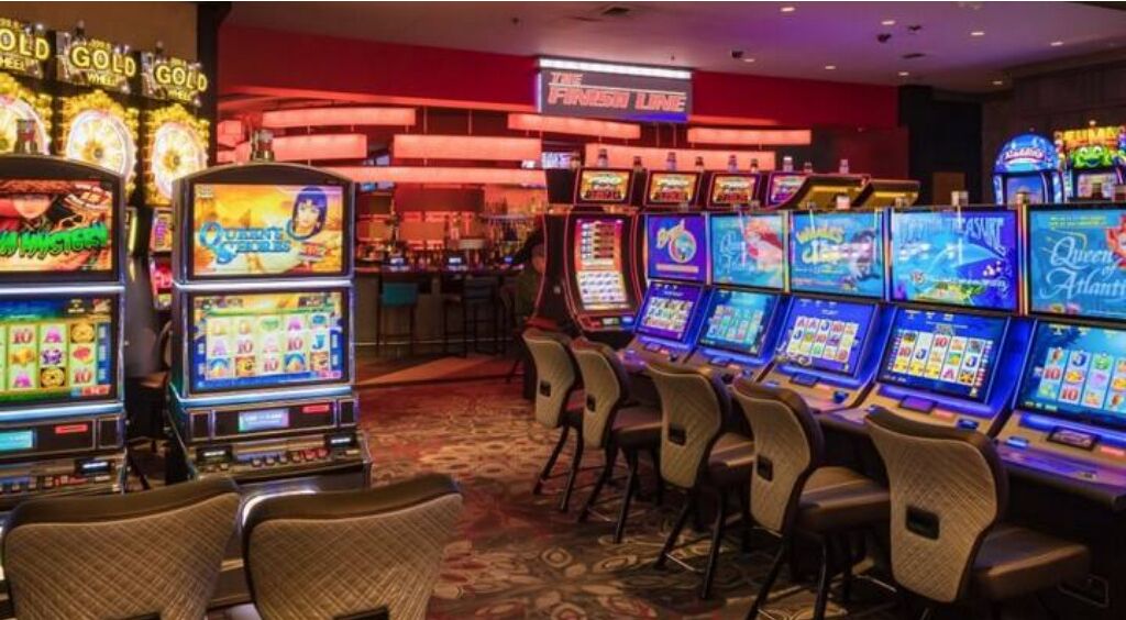 Ett kasinorum med ett stort antal spelautomater, en bar och en skylt med texten ”Det bästa utbudet”.