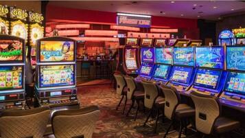 Ett kasinorum med ett stort antal spelautomater, en bar och en skylt med texten ”Det bästa utbudet”.