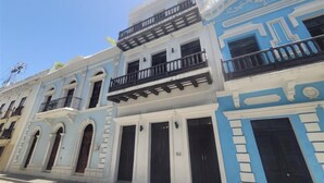 A row of colonial-style buildings with balconies and arched doorways. - 153 Luna by Stay with Bear (San Juan)
