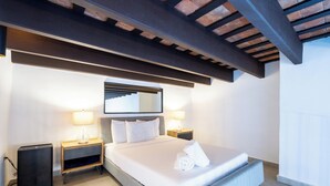 A modern hotel room with a large bed, bedside lamps, a small bedside table, and a mirror on the wall. - 153 Luna by Stay with Bear (San Juan)