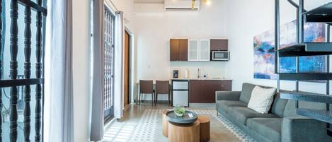 Una sala de estar moderna con sofá, mesa de centro y comedor.
