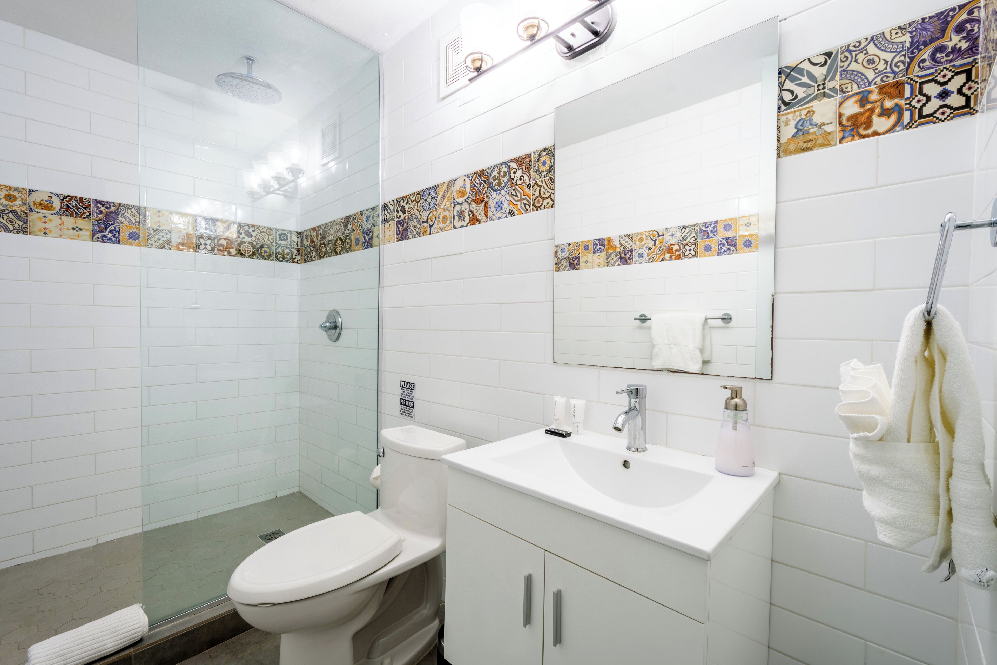A bathroom with a toilet, sink, and shower.