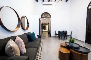 Un interior moderno con un sofá, una mesa de centro y un comedor con sillas y una mesa.
