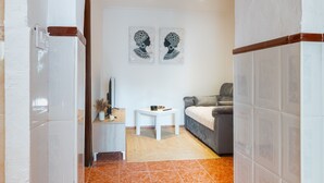 Un salon moderne comprenant un canapé, une table basse et deux œuvres d’art accrochées au mur.