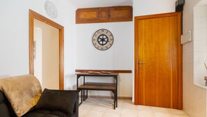 Un salon avec un canapé, une table en bois, une horloge et une porte.
