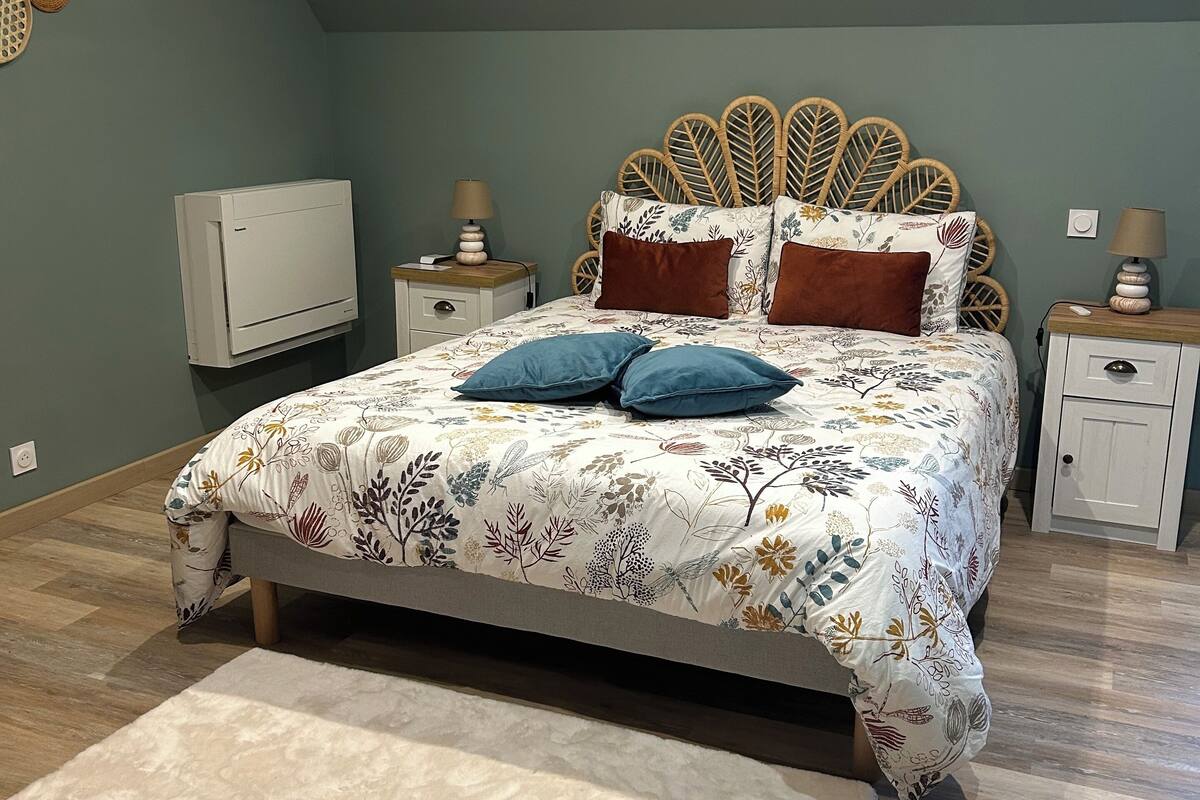 A bedroom with a bed, nightstands, a TV, and a rug.