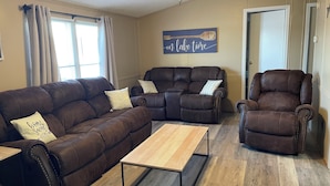 A living room with a brown leather sectional sofa, a recliner, and a coffee table. - 3-bedroom home on beautiful Lake Greenwood, close to Old Eight Golf Course. (Waterloo)