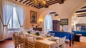 A dining room with a table set for six, wooden chairs, and a chandelier. - Tenuta dei Mandorli Pool Wifi Peccioli (Peccioli)