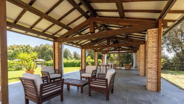 An outdoor patio with wooden furniture and a brick column structure. - Tenuta dei Mandorli Pool Wifi Peccioli (Peccioli)