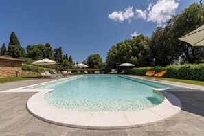 Piscine extérieure en saison, parasols, chaises longues