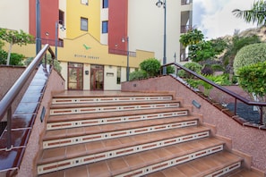 Una escalera conduce a un edificio con un cartel que dice 'OLIVIA SUNSET'.