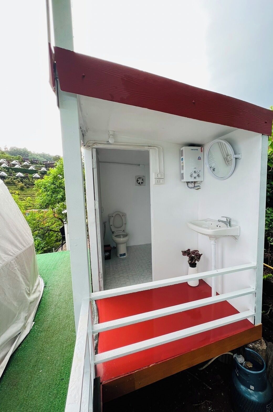 Een compacte, afgesloten badkamer met toilet, wastafel en een wandradiator.