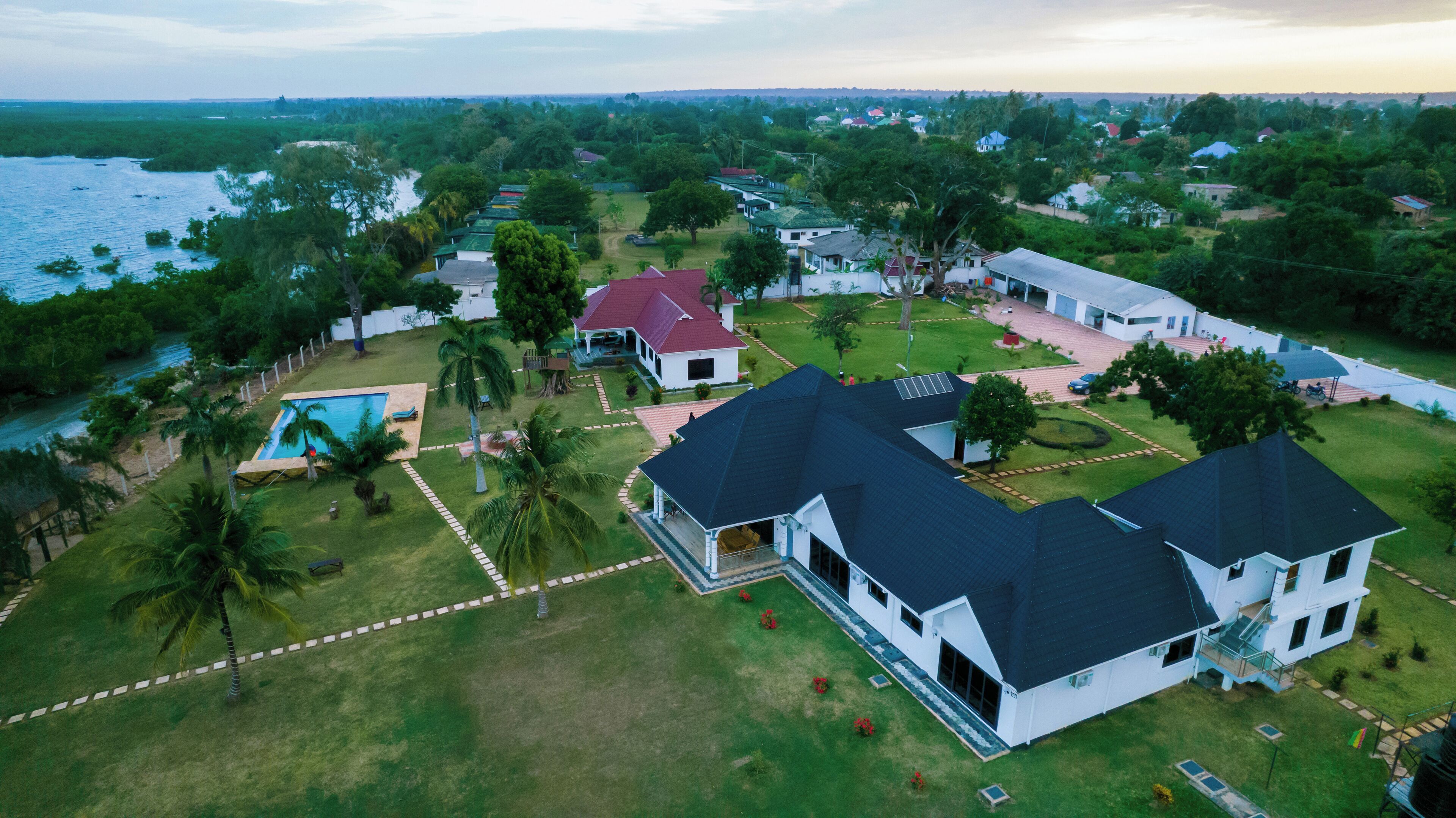 Vista aérea de una zona residencial con casas, una piscina y un río.