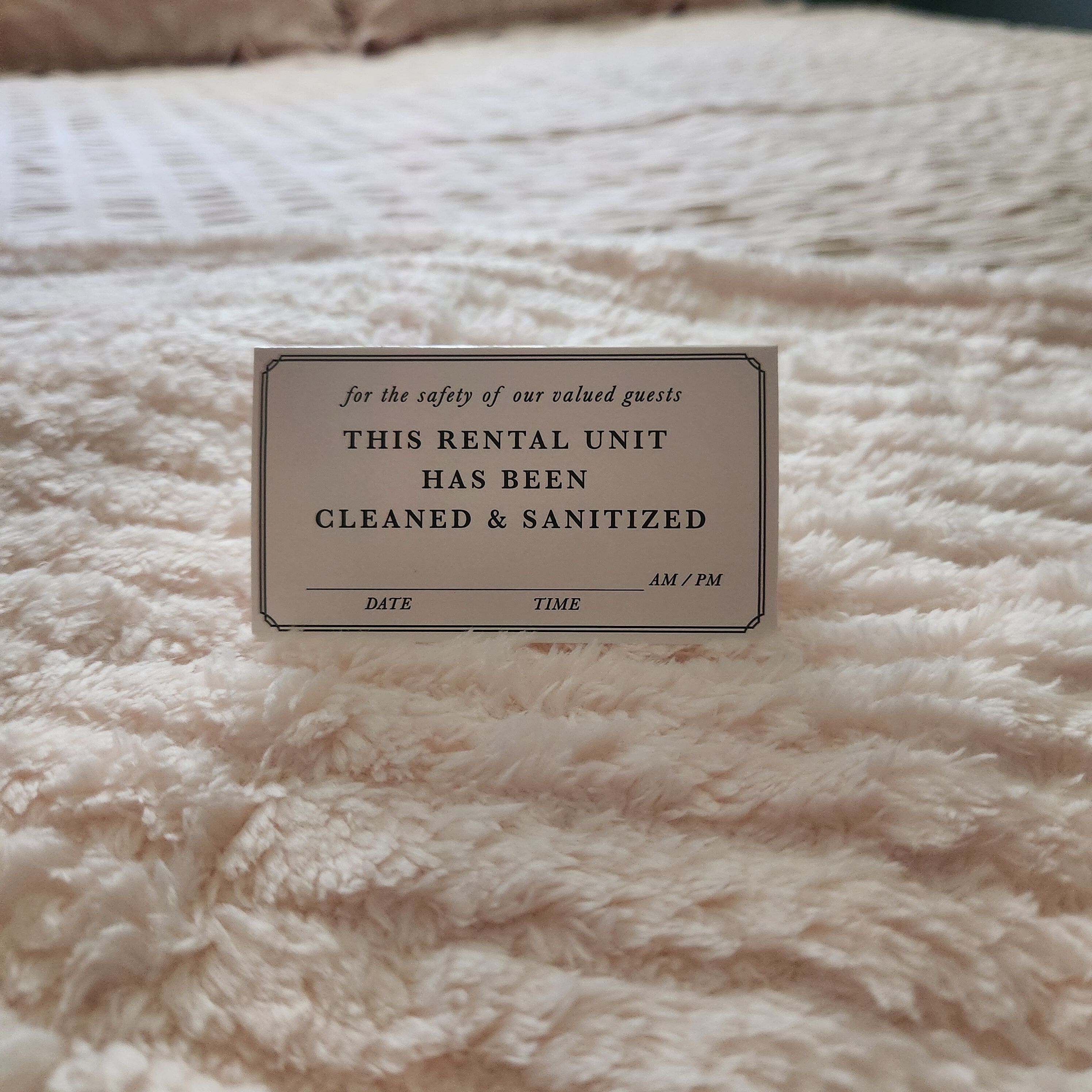 A sign on a fluffy white carpet indicating a rental unit has been cleaned and sanitized.