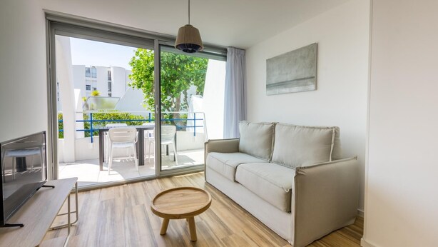 A modern living room with a sofa, a small wooden table, and a TV.